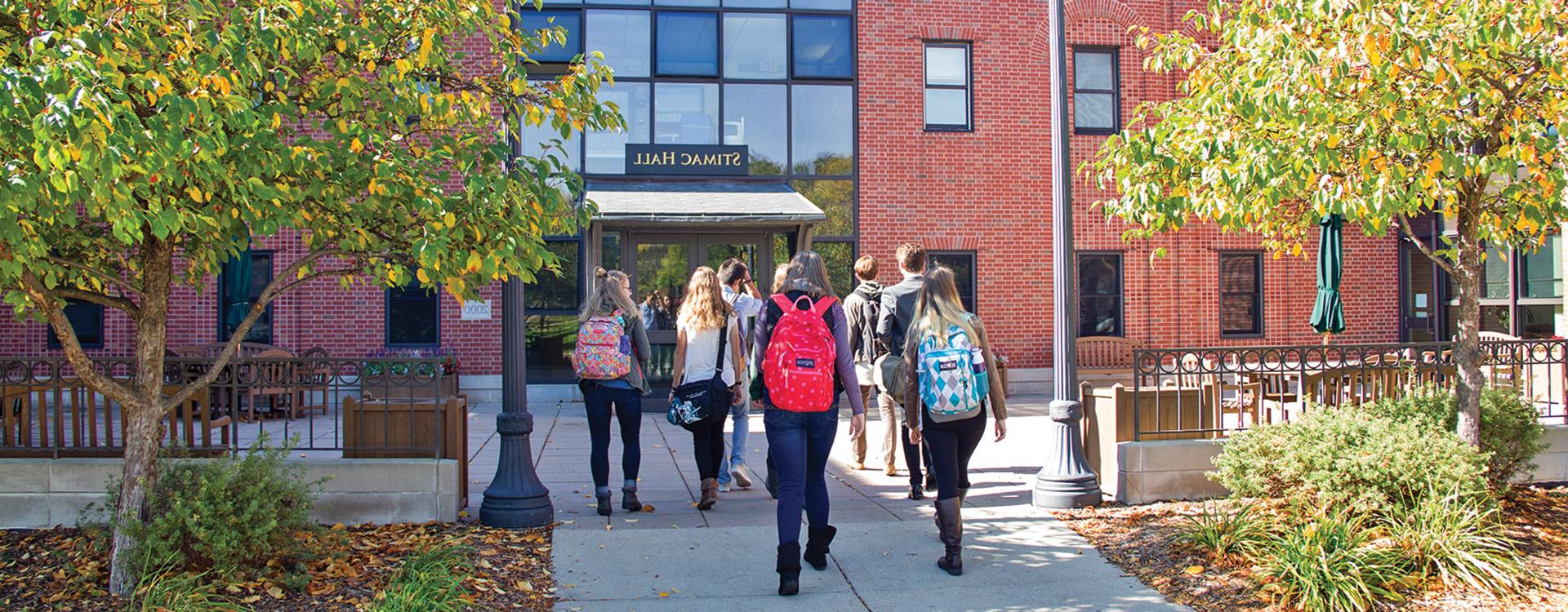 Students walking into Stimac Hall in autumn